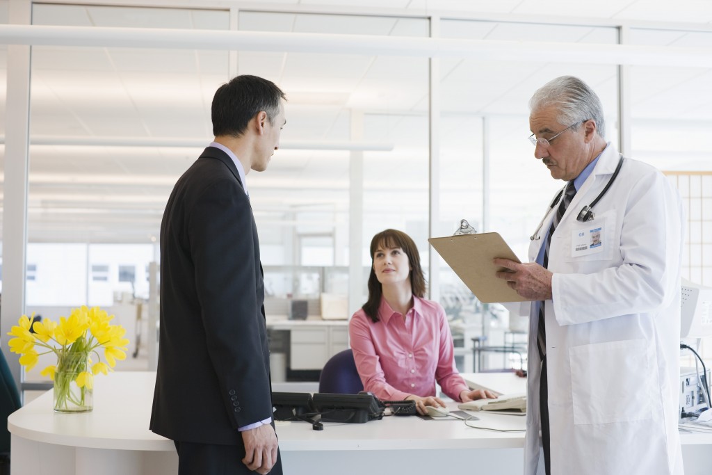 Businessman and doctor by receptionist