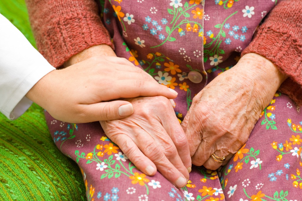 A doctor holding/ shaking an old womans hand - part of a series.