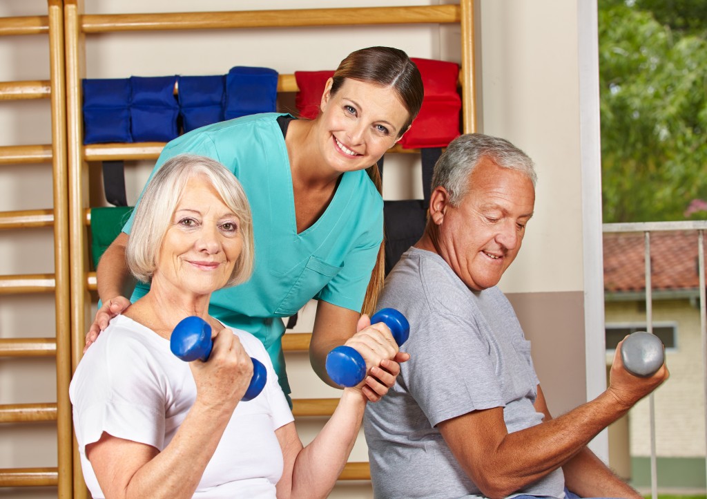 Zwei Senioren heben Hanteln beim Training in der Physiotherapie